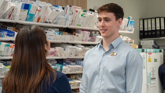 A male and a female pharmacist are talking to each other in Boots Pharmacy