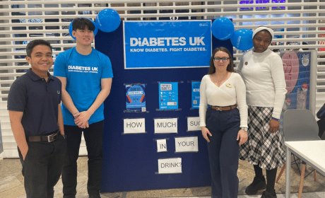 Four Trainee Pharmacists stand in front of an event board with a sign for Diabetes UK