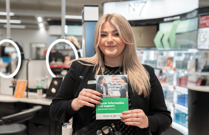No7 Advisor standing with Macmillan information poster