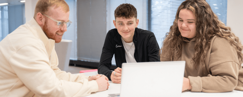 Apprentices working together on a laptop